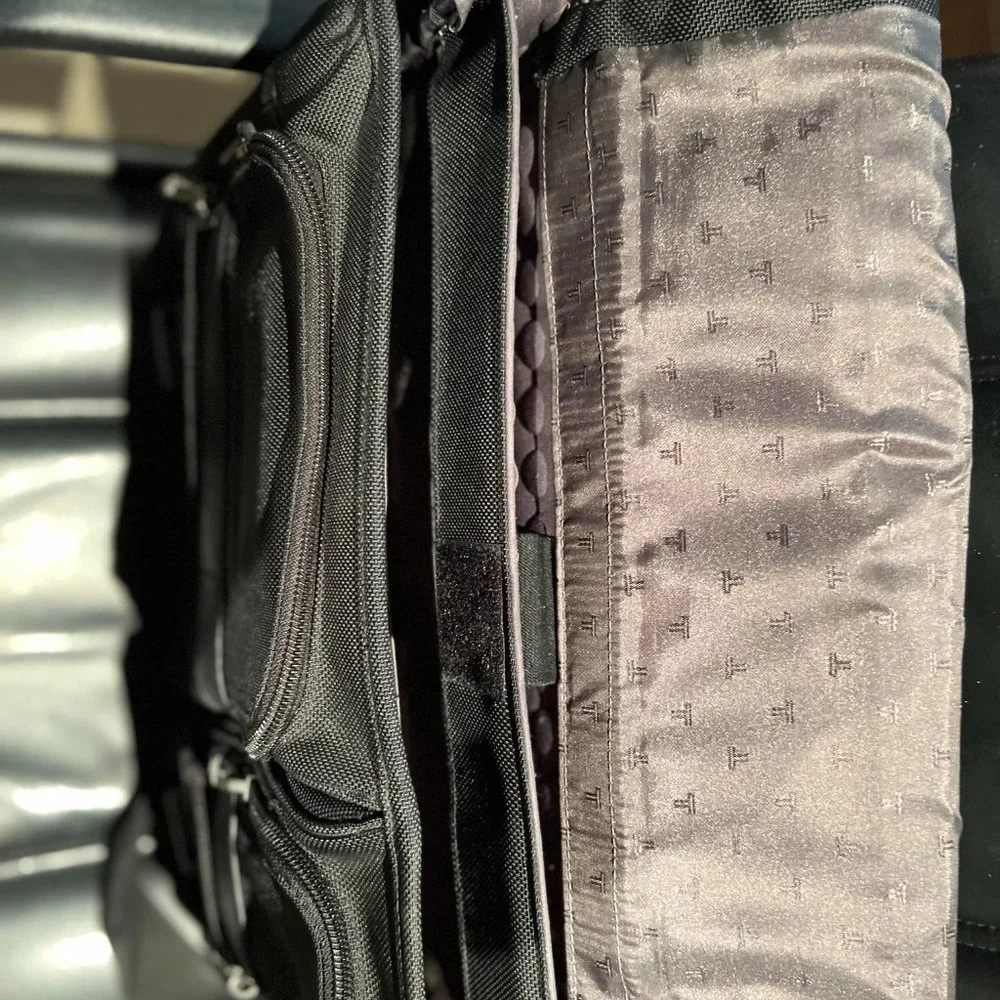 TUMI EXPANDABLE BRIEF CASE BLACK INSIDE POCKETS AND 4 OUTSIDE POCKETS,